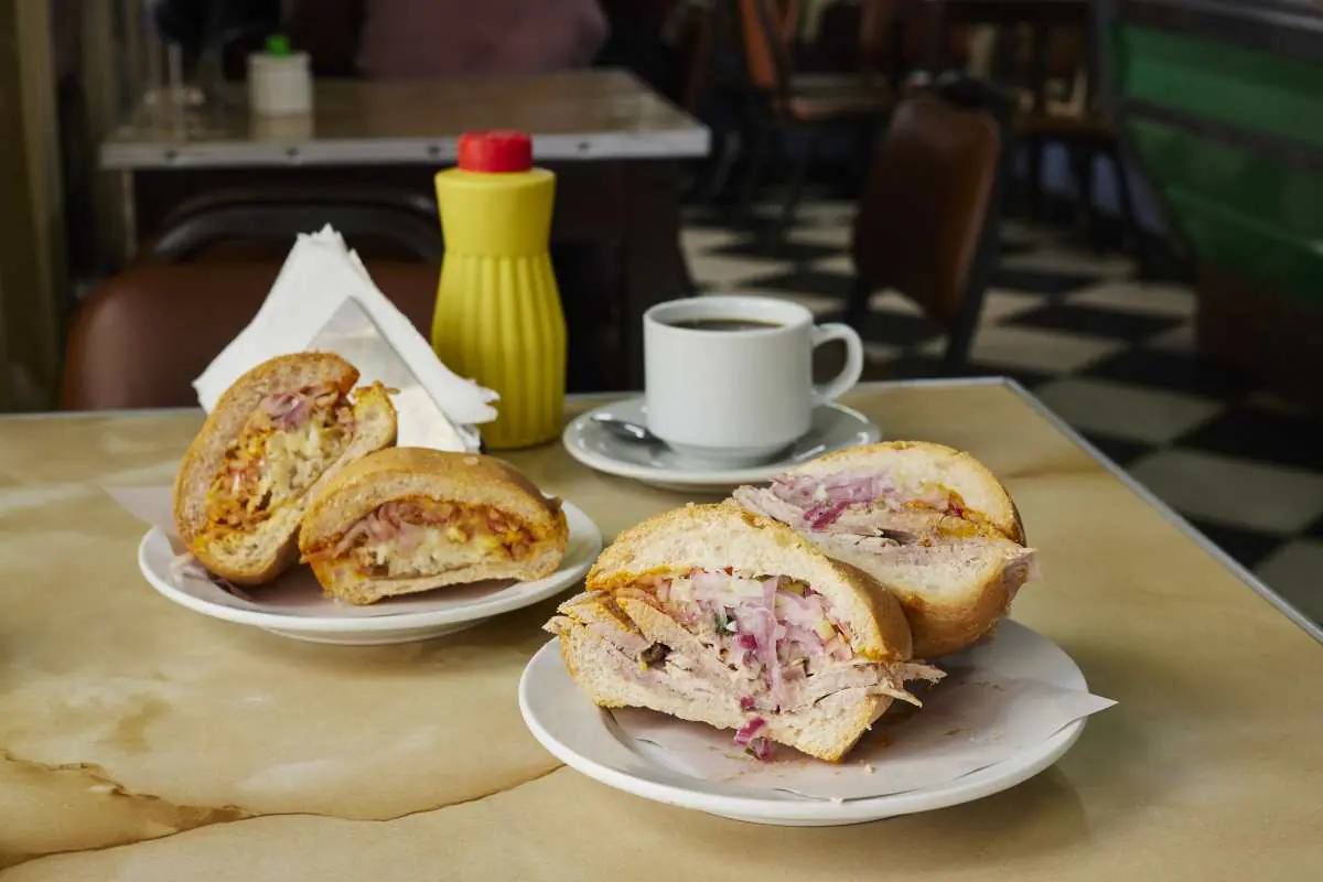 Sandwiches and a coffee on a table at Bodega Carbone, photographed by Jimena Agois.