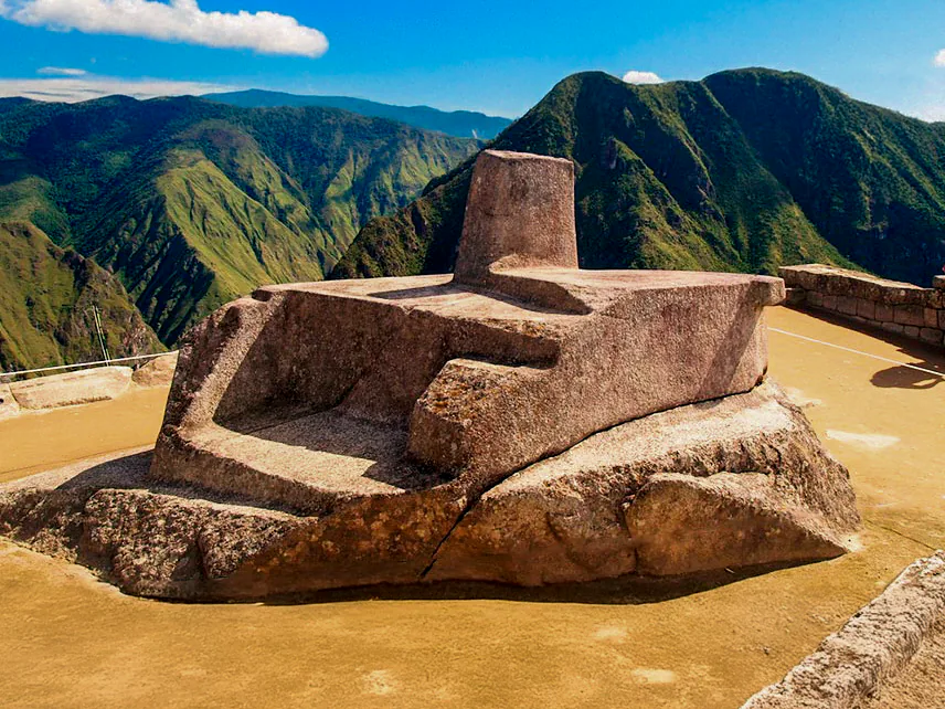 The carved Intihuatana stone against the green mountains of Machu Picchu