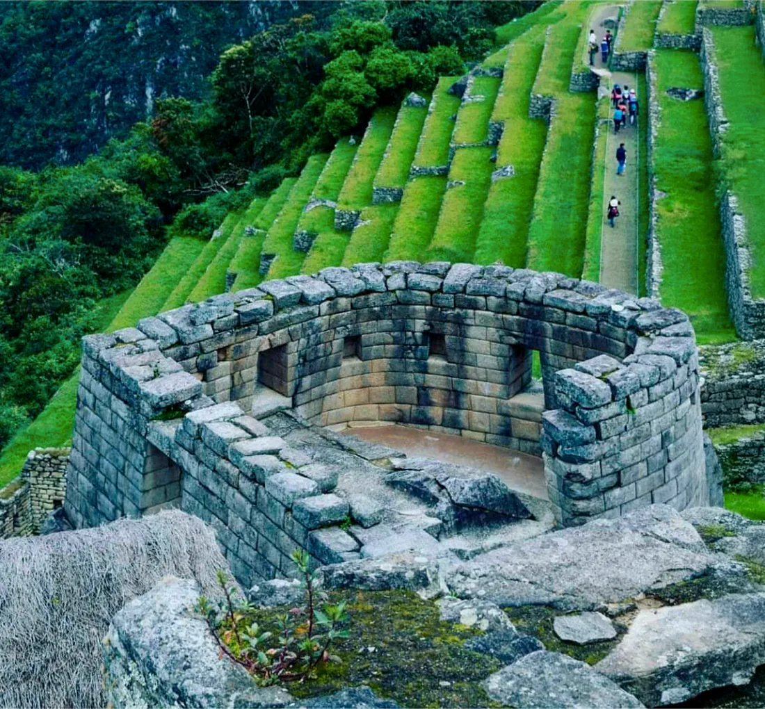 The curved fitted-stone wall of the Temple of the Sun above a natural rock outcrop