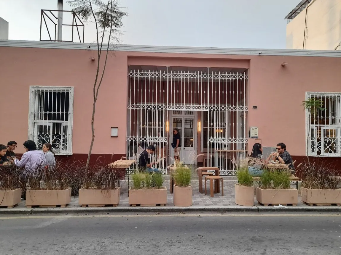 The pink facade and outdoor tables at Demo, Domeyer 282