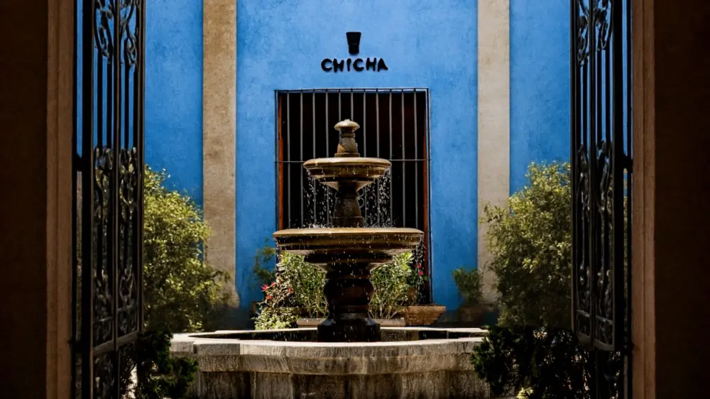 The blue entrance and courtyard fountain at Chicha Arequipa
