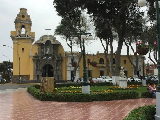 The historic yellow facade of La Ermita beside the square