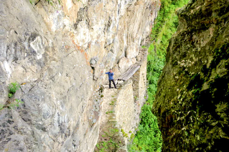 A narrow Inca-built access path along the sheer cliff at the Inca Bridge sector