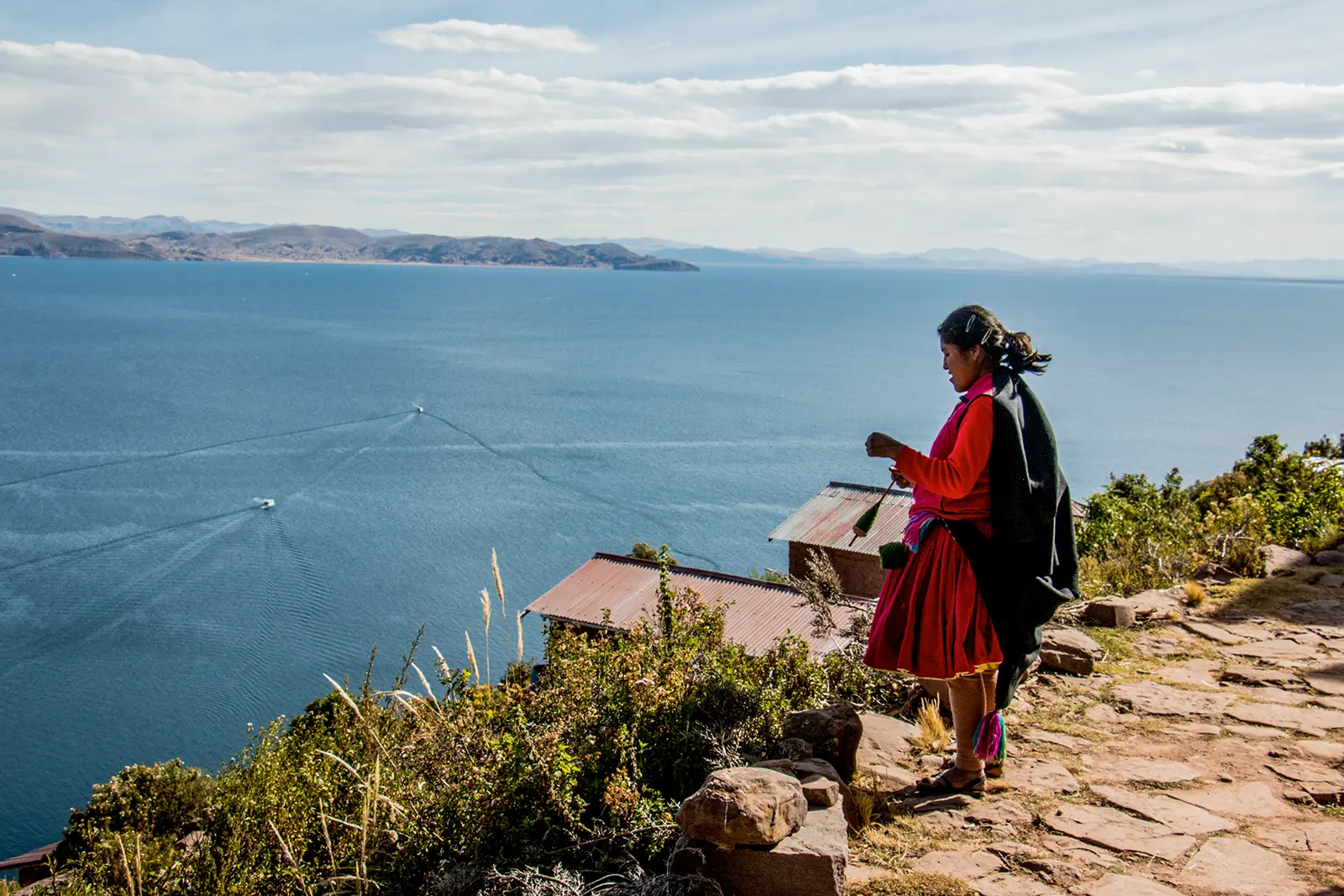 A woman working with thread above Lake Titicaca on Taquile